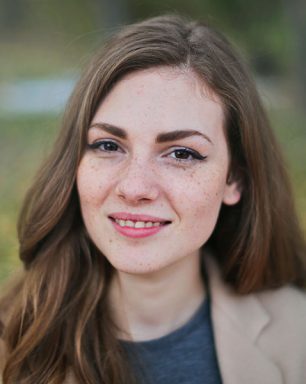 a woman with freckled hair is smiling for the camera.